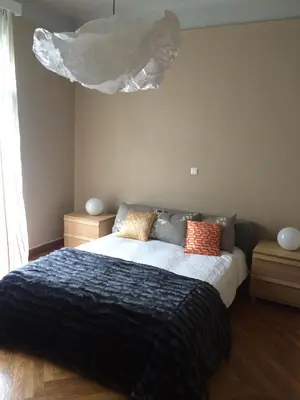 a bedroom with a bed with a black blanket and orange pillows at Lux Kolonaki Apartment in Athens
