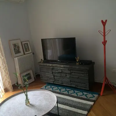 a living room with a flat screen tv and a table at Lux Kolonaki Apartment in Athens