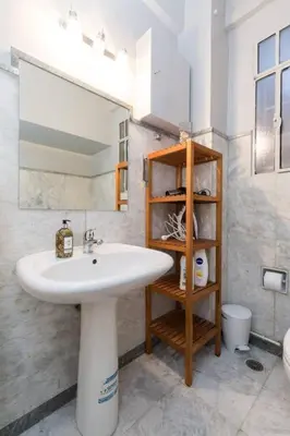 a bathroom with a sink and a mirror at Irodotou Grand Apartment in Athens