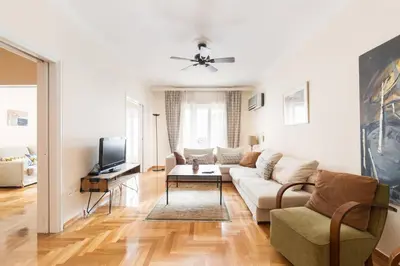 a living room with a couch and a tv at Irodotou Grand Apartment in Athens