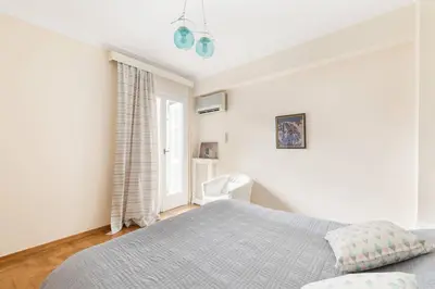 a white bedroom with a bed and a window at Irodotou Grand Apartment in Athens