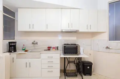 a kitchen with white cabinets and a microwave on a counter at Irodotou Grand Apartment in Athens