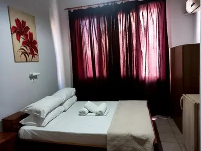 a bed in a room with a red window at Hotel Korydallos in Piraeus