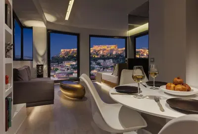 a dining room with a table and chairs and windows at Athens Avaton Suites in Athens
