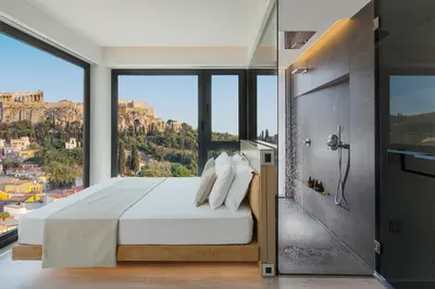 a bedroom with a bed and a view of the city at Athens Avaton Suites in Athens