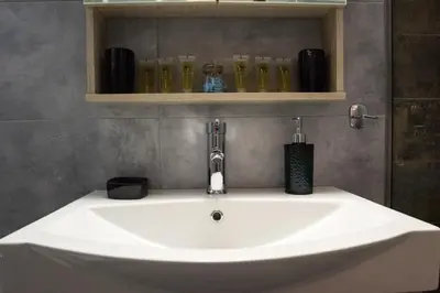 a sink with a faucet in a bathroom at Gazi Divine Apartment in Athens