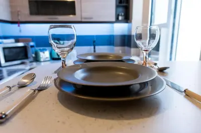 a table with two plates and two wine glasses at Gazi Divine Apartment in Athens