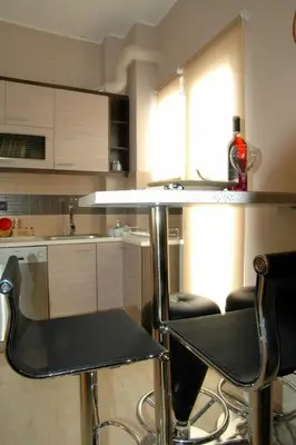 a kitchen with a counter and two bar stools at Gazi Divine Apartment in Athens