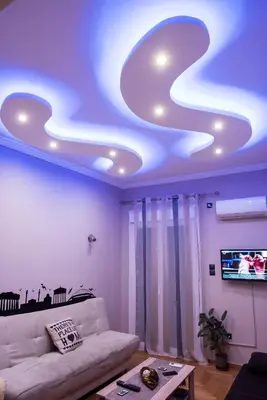 a living room with a couch and a tv on a ceiling at Gazi Divine Apartment in Athens