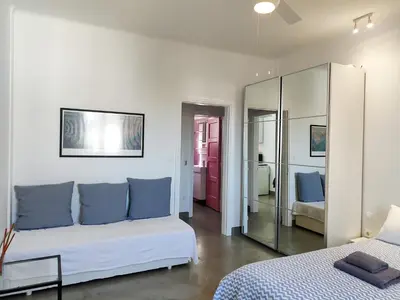 a white bedroom with a bed and a mirror at KYMA Apartments - Athens Acropolis 8 in Athens