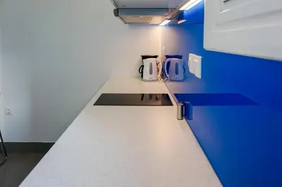 a kitchen with a white counter and a blue wall at KYMA Apartments - Athens Acropolis 8 in Athens