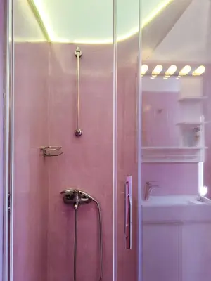a shower with a glass door next to a sink at KYMA Apartments - Athens Acropolis 8 in Athens