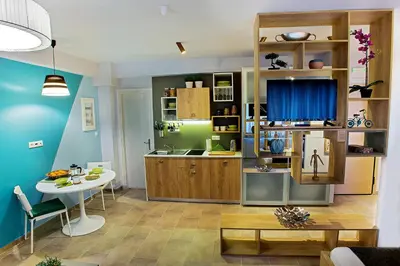 a living room with a table and a kitchen at Emerald Suite in Athens