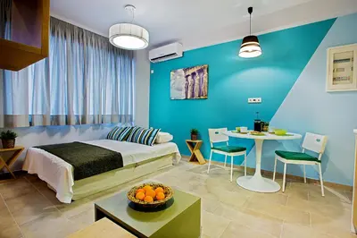 a bedroom with a bed and a table and a dining room at Emerald Suite in Athens