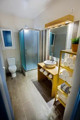 a bathroom with a sink and a toilet and a mirror at Emerald Suite in Athens
