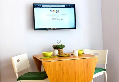 a table with two chairs and a tv on a wall at Emerald Suite in Athens