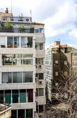 a tall apartment building with trees in front of it at Emerald Suite in Athens