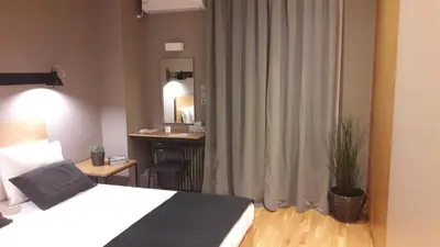 a bedroom with a bed and a desk and a mirror at Phaedra Apartment in Athens