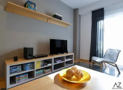 a living room with a television and a table with a bowl of food at Phaedra Apartment in Athens