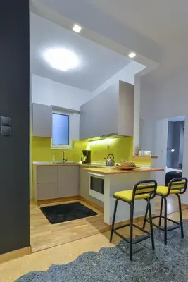 a kitchen with two chairs and a table and a counter at Phaedra Apartment in Athens