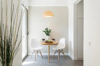 a dining room with a table and white chairs at Homz Studios Faliro in Athens