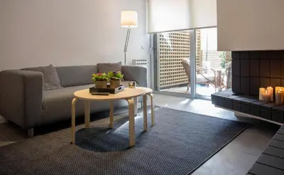 a living room with a couch and a table at Homz Studios Faliro in Athens