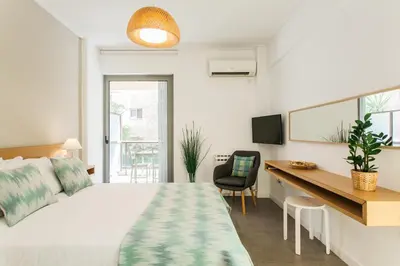 a bedroom with a bed and a desk with a computer at Homz Studios Faliro in Athens