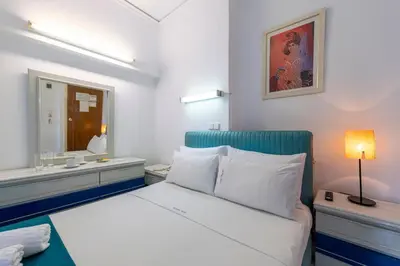a white bedroom with a bed and a mirror at ROY Hotel in Athens