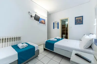 a hotel room with two beds and a desk at ROY Hotel in Athens
