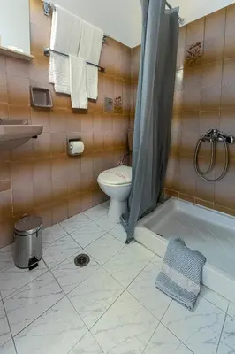 a bathroom with a toilet and a sink and a tub at ROY Hotel in Athens