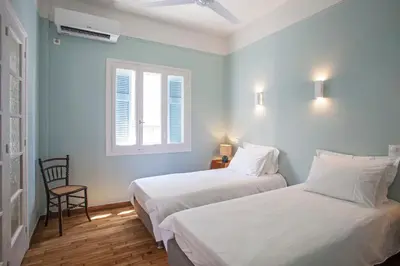 two beds in a room with a chair and a window at Lovely two-bedroom apartment with roof garden! EP7 in Athens