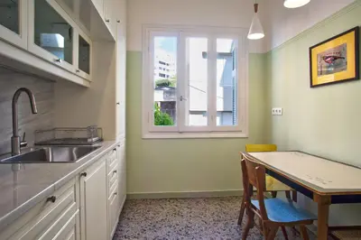 a kitchen with a sink and a table and a window at Lovely two-bedroom apartment with roof garden! EP7 in Athens