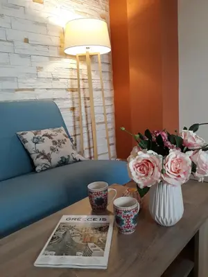 a table with two cups and a vase with flowers at Paradise Apartment in Peiraiki in Piraeus