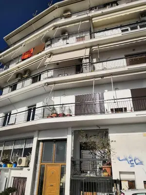 a large white building with balconies and a window at Paradise Apartment in Peiraiki in Piraeus