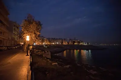 a street light next to a body of water at night at Paradise Apartment in Peiraiki in Piraeus