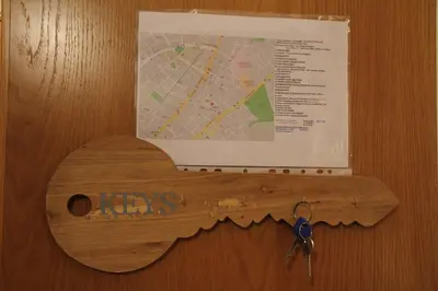 a wooden airplane key on a door with a map at Ouranos Apartment in Athens