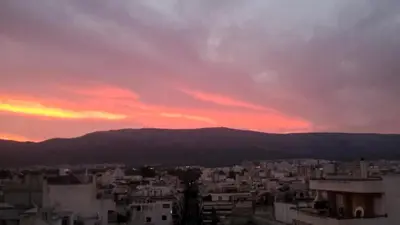 a view of a city at sunset at Ouranos Apartment in Athens