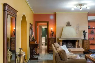 a living room with a couch and a fireplace at 165 sm Penthouse Maisonette Apartment in Athens