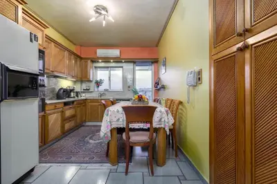 a small kitchen with a table and a refrigerator at 165 sm Penthouse Maisonette Apartment in Athens