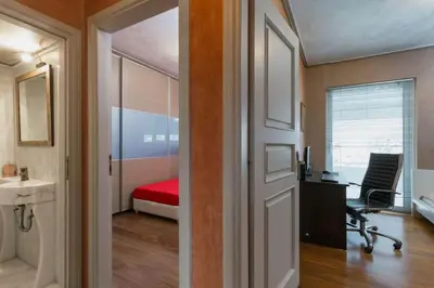an open door to a room with a desk and a bedroom at 165 sm Penthouse Maisonette Apartment in Athens