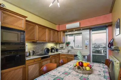 a kitchen with a table with a bowl of fruit on it at 165 sm Penthouse Maisonette Apartment in Athens