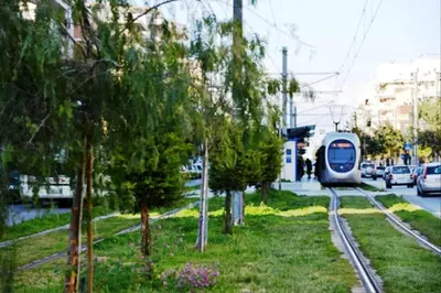 a train traveling down the tracks next to trees at 165 sm Penthouse Maisonette Apartment in Athens