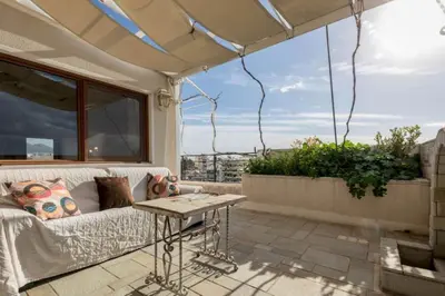 a patio with a couch and a table on a balcony at 165 sm Penthouse Maisonette Apartment in Athens