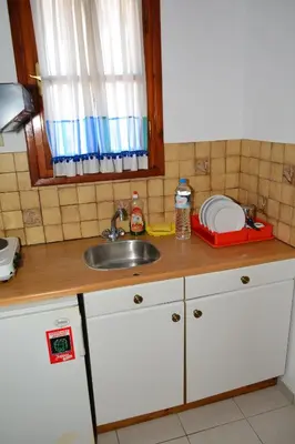 a kitchen counter with a sink and a mirror at Aiolos in Vaia