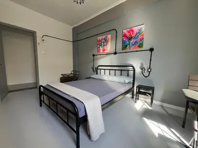 a bedroom with a bed and two paintings on the wall at Urban Rooms in Athens