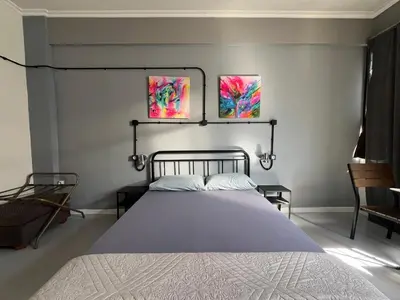 a bedroom with a bed and two paintings on the wall at Urban Rooms in Athens
