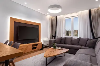 a living room with a couch and a flat screen tv at Acropolis Exclusive Residences in Athens