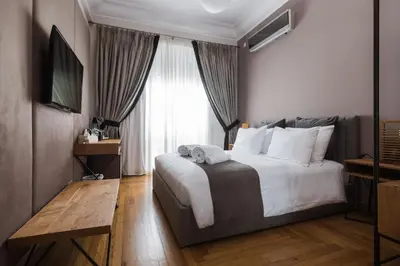 a hotel room with a large bed and a window at Acropolis Exclusive Residences in Athens