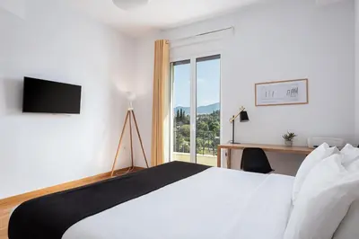 a bedroom with a bed and a desk and a window at Acropolis Exclusive Residences in Athens