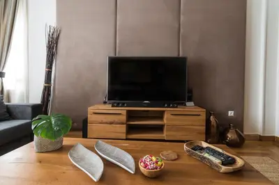 a living room with a tv and a wooden table at Acropolis Exclusive Residences in Athens